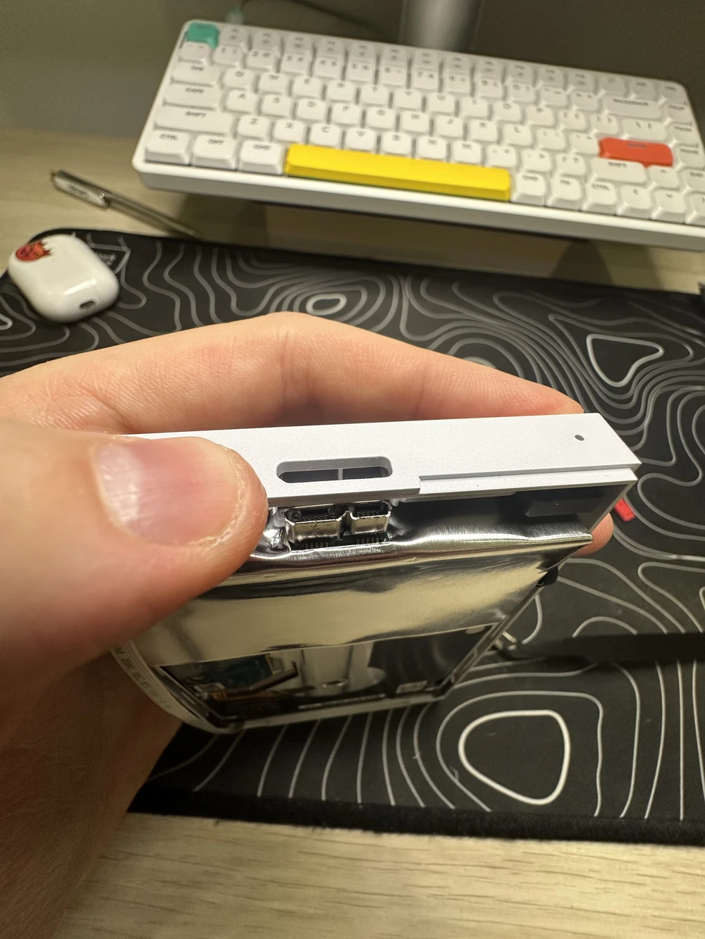 Pulling up on the plastic cover near the USB Micro-B socket to remove the drive from the enclosure